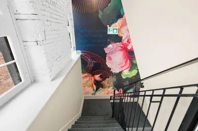 a stairway with a mural of flowers on the wall at Arcadia Hotel Boutique in Montréal
