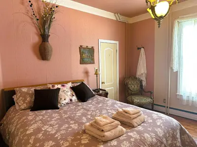a bedroom with a bed with towels on it at Ô Café Crème in Magog-Orford