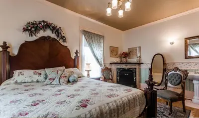 a bedroom with a large bed and a fireplace at Ô Café Crème in Magog-Orford