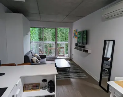 a living room with white walls and a large window at Cozy Studio in Montreal's Quartier des Spectacles in Montréal