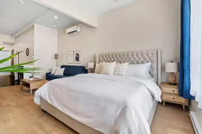 a bedroom with a large bed and a blue couch at Central King Studio in Montréal