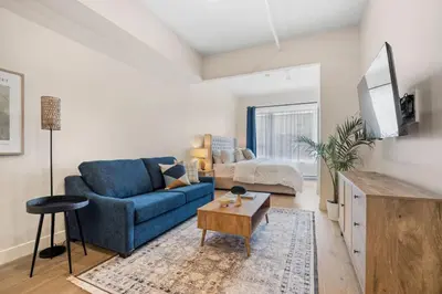 a living room with a blue couch and a table at Central King Loft in Montréal