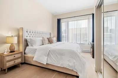 a white bedroom with a large bed and a window at Central King Loft in Montréal