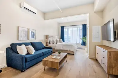 a living room with a blue couch and a bed at DownTown King Suite in Montréal