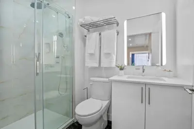 a white bathroom with a toilet and a shower at DownTown King Suite in Montréal