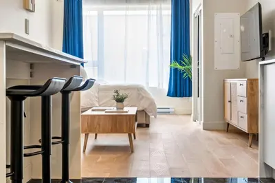 a living room with blue curtains and a table at DownTown King Suite in Montréal
