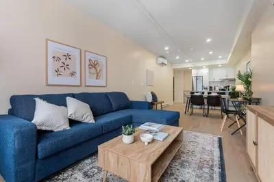 a living room with a blue couch and a table at Double King Luxury 2BR Condo in Montréal