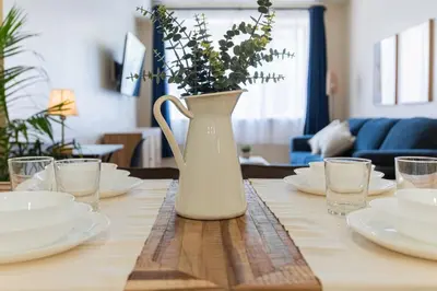 a white vase with flowers on a wooden table at Double King Luxury 2BR Condo in Montréal