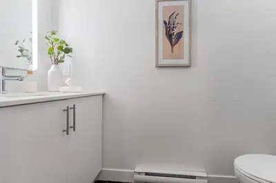 a white bathroom with a sink and a toilet at Double King Luxury 2BR Condo in Montréal