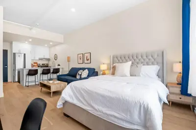 a bedroom with a large bed and a blue couch at Luxurious DownTown Suite in Montréal