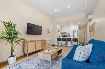 a living room with a blue couch and a tv at City Center King Loft in Montréal
