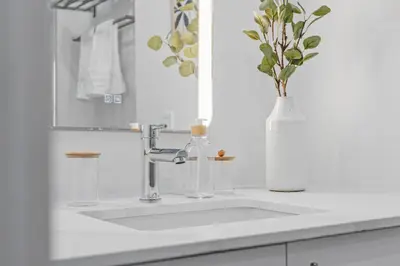 a bathroom sink with a vase of flowers on it at City Center King Loft in Montréal