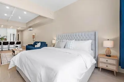 a bedroom with a white bed and a blue couch at City Center King Loft in Montréal