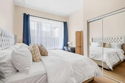 a bedroom with a large white bed and a mirror at City Center King Loft in Montréal
