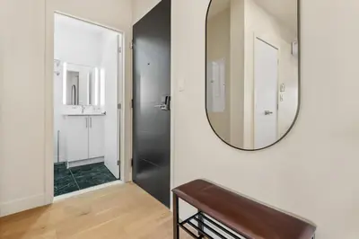 a mirror on a wall in a room with a bathroom at City Center King Suite in Montréal