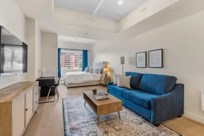 a living room with a blue couch and a bed at DownTown King Loft in Montréal