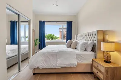 a bedroom with a large bed with blue curtains at DownTown King Loft in Montréal