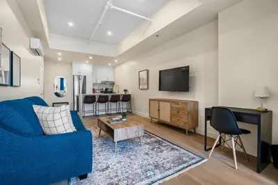 a living room with a blue couch and a tv at DownTown King Loft in Montréal