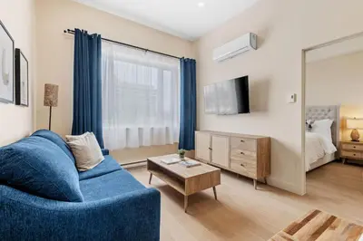 a living room with a blue couch and a mirror at Stylish 2BR Retreat in Montréal