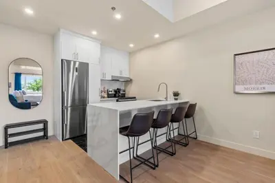 a kitchen with a bar with stools and a refrigerator at Luxe DownTown King Suite in Montréal