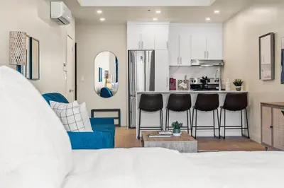 a living room with a blue couch and a kitchen at Luxe DownTown King Suite in Montréal