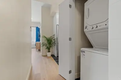 a kitchen with white appliances and a plant in a hallway at Downtown 2BR Suite in Montréal