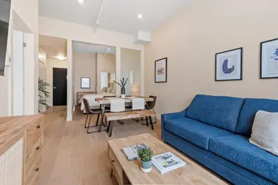a living room with a blue couch and a table at Downtown 2BR Suite in Montréal