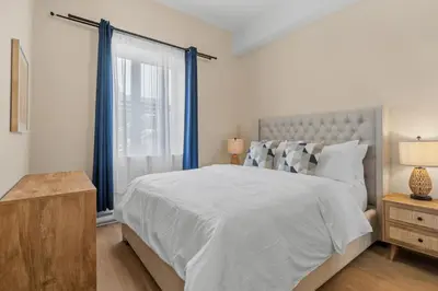 a bedroom with a large bed and a window at Downtown 2BR Suite in Montréal