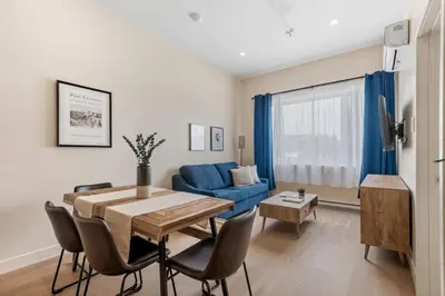 a living room with a table and a blue couch at Downtown 2BR condo in Montréal