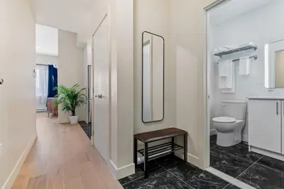 a bathroom with a toilet and a mirror at City Center 2BR Condo in Montréal