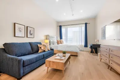a living room with a blue couch and a bed at Central Studio in Montréal