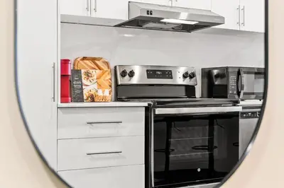 a view of a kitchen through a mirror at Central Suite with Balcony in Montréal