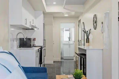 a kitchen with white walls and a blue couch at Central Suite with Balcony in Montréal