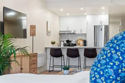 a kitchen with three bar stools in a room at Luxurious King Suite with Balcony in Montréal
