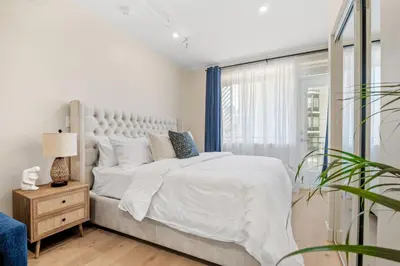 a white bedroom with a large bed and a window at Luxurious King Suite with Balcony in Montréal
