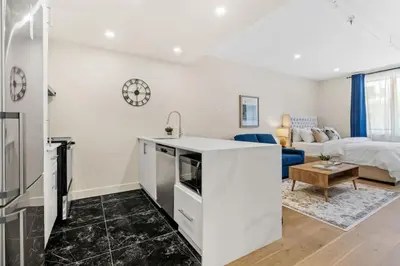 a kitchen and living room with a sink and a couch at DownTown Studio with Balcony in Montréal