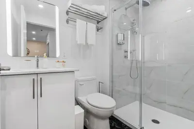 a white bathroom with a toilet and a shower at DownTown Studio with Balcony in Montréal
