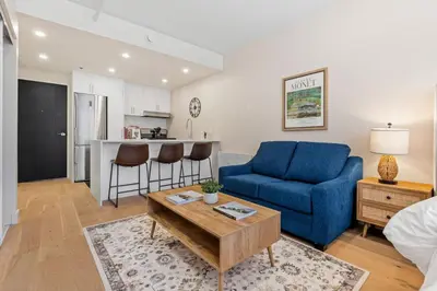 a living room with a blue couch and a table at DownTown Studio with Balcony in Montréal