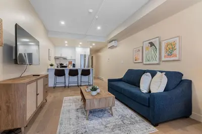 a living room with a blue couch and a kitchen at DownTown King Suite with Balcony in Montréal