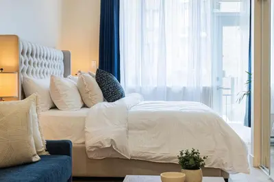 a bedroom with a bed with pillows and a window at DownTown King Suite with Balcony in Montréal