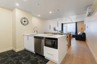 a kitchen with a sink and a microwave at 2BR Downtown Suite with Balcony in Montréal