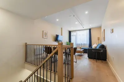 a room with a staircase and a living room at 2BR Downtown Suite with Balcony in Montréal