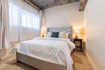 a bedroom with a large bed and a window at 2BR Downtown Suite with Balcony in Montréal