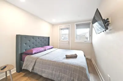 a bedroom with a bed with purple pillows and a tv at Cozy 3BDR in heart of plateau Montreal D in Montréal