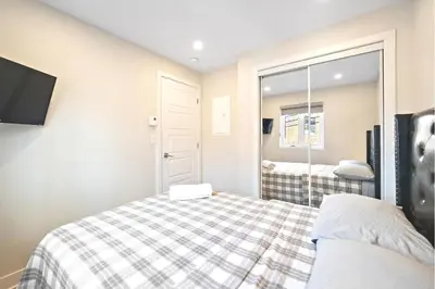 a small bedroom with a bed and a mirror at Cozy 3BDR in heart of plateau Montreal D in Montréal