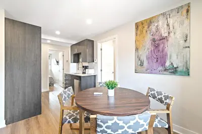 a kitchen and dining room with a wooden table and chairs at Cozy 3BDR in heart of plateau Montreal D in Montréal