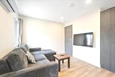 a living room with a couch and a flat screen tv at Cozy 3BDR in heart of plateau Montreal D in Montréal