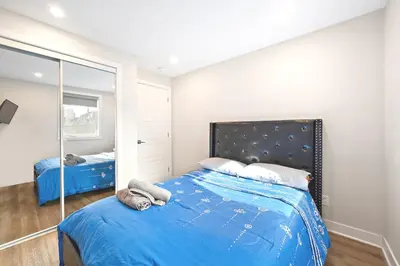 a bedroom with a blue bed and a mirror at Cozy 3BDR in heart of plateau Montreal D in Montréal