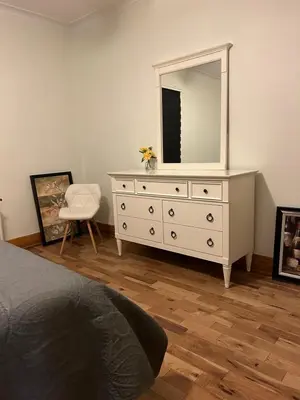 a bedroom with a dresser with a mirror and a chair at Walk on the riverside in Montréal