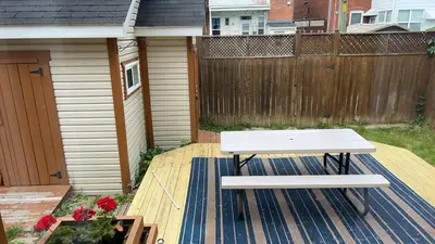 a white bench sitting on a deck next to a fence at Walk on the riverside in Montréal